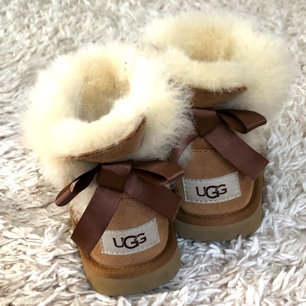 Ugg boots; lightly warn; toddler girls size 9; tan with bow.